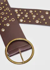 Cinto blanco de cuero sintético con hebilla redonda dorada y tachas doradas de diferentes formas.