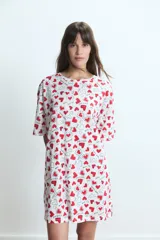 Camisón de algodón con estampado de corazones rojos y frases románticas sobre fondo blanco, de corte holgado y manga corta.
