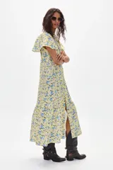 Vestido midi amarillo con estampado floral celeste, de corte recto, con cuello mao y abertura frontal con botones.