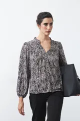 Camisa de manga larga marrón con estampa de lunares blancos, cuello en V con volados y cierre frontal abotonado.