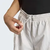 Short de running Adidas de corte holgado, color gris claro, con bolsillos laterales amplios y logo de la marca en el bajo. Cuenta con cintura elástica y cordón de ajuste.