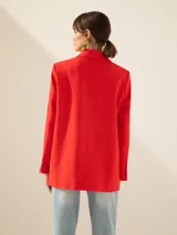 Blazer rojo de lino, cruzado, con solapas de muesca, dos botones de pasta a tono en el cruce y botones en los puños.