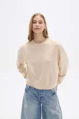 Buzo color beige de corte ancho y cuello redondo.