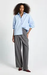 Camisa de corte oversize color celeste, con cuello clásico, cierre frontal de botones y mangas largas con puños abotonados.