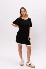 Vestido corto negro de tejido de punto calado, con cuello redondo y mangas cortas con ribete blanco.