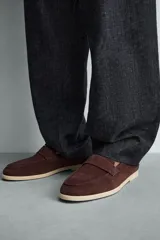 Mocasín casual de hombre, color marrón oscuro (bordó), fabricado en piel con acabado serraje (gamuza). Presenta un detalle de antifaz en el empeine y suela a contraste de color beige claro.