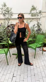 Top de encaje negro con breteles finos y escote con abertura.