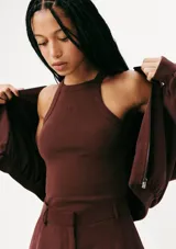 Musculosa de tejido acanalado en color naranja, con cuello redondo alto y detalle de pequeño bordado central en el pecho.