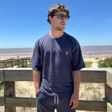 Remera azul marino tejida con cuello redondo y manga corta, con logo bordado en el pecho.