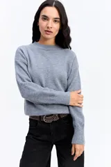 Buzo de punto de textura suave, color malva, con cuello redondo y diseño de calce relajado.