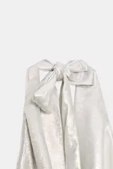 Top asimétrico plateado metalizado con cuello halter ajustable mediante lazada y escote drapeado tipo pañuelo.