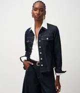 Campera de jean color azul oscuro, con diseño entallado, cuello camisero, mangas largas con puños abotonados y cierre frontal con botones metálicos. Presenta recortes estructurales que realzan la silueta.