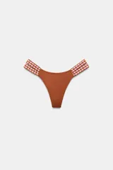 Braguita de bikini de tiro medio, color tostado, con tiras dobles en los laterales con aplique de crochet en tonos rosados y tostados.
