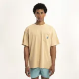 Remera color arena de corte holgado, con cuello redondo y bolsillo en el pecho con etiqueta azul.