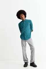 Camisa de manga larga color crema, con cuello camisero y botones frontales. Corte ajustado.