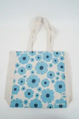 Bolso tote de tela con estampado de rayas verticales rosadas y blancas, laterales y asas en color beige. Presenta la palabra "BONJOUR" en verde en el centro y "INDIAN" en la parte inferior.