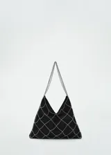 Bolso de mano pequeño con diseño de red de cadenas metálicas plateadas sobre una base de tejido de guipur negro. Cuenta con asas cortas de cadena.