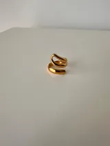 Anillo de diseño abierto y forma sinuosa, fabricado en acero quirúrgico con acabado pulido brillante.