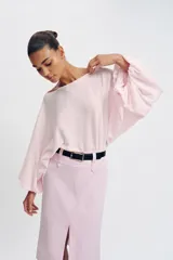 Falda midi tubo de color rosado con abertura frontal en el bajo y cierre lateral con cremallera oculta. Incluye un cinturón negro con hebilla dorada.
