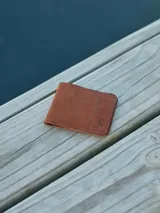 Billetera de cuero color negro, con múltiples ranuras para tarjetas y compartimento para billetes.