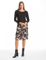 Vestido midi de diseño combinado con parte superior tipo remera de manga larga en color negro y falda fluida con estampado animal print en tonos tierra y negro. Presenta cuello redondo y cintura elastizada.