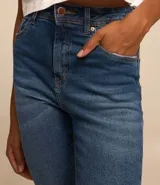 Pantalón de jean skinny azul con cintura alta y detalles de desgaste en los bolsillos.