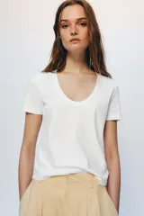Camiseta de algodón con corte regular, escote redondo amplio y manga corta. Presenta un diseño básico con bajo recto.