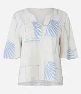 Blusa de manga corta en viscosa color beige, con escote en V con detalle de tira y cuenta de madera, y estampado geométrica y de follaje en tonos celestes.