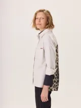 Camisa de corte clásico con frente en color beige, mangas con puños en contraste color negro y espalda con estampado animal print. Presenta cuello camisero, cierre frontal con botones y bolsillo en el pecho.