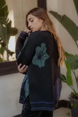 Sweater de tejido grueso color borgoña con estampado de flores abstractas en tonos azul y gris.