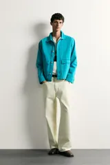 Cazadora relaxed fit de denim de algodón color turquesa, con cuello solapa, manga larga con puño abotonado, bolsillos frontales con solapa y cierre de botones metálicos.