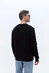 Sweater de cuello redondo con textura de tejido marcado, manga larga y puños acanalados.
