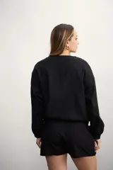 Chaqueta tipo bomber color negro, con cierre frontal metálico, cuello redondo y puños elásticos.