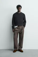 Sweater de punto negro de corte regular fit, confeccionado en algodón con cuello redondo, manga larga y acabados en rib.