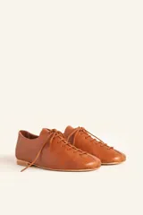 Zapato tipo oxford plano de cuero vacuno en color azul marino, con cordones al tono y suela de cuero.