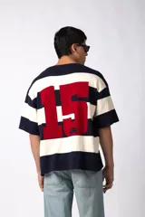 Remera tejida de manga corta con diseño de rayas horizontales anchas en color bordó y crema, de corte relajado y cuello redondo.