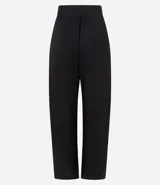 Pantalón de sastrería corte barrel, color marrón oscuro, con pliegues delanteros, cintura con cierre desplazado y piernas anchas.