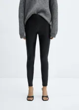 Leggings de tiro alto con efecto piel, confeccionados en tejido con recubrimiento de poliuretano. Presentan un diseño ajustado y elástico en la cintura, sin cierre.