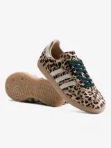 Zapatillas Adidas Samba OG W con diseño de estampado animal print de leopardo. Presentan las icónicas tres franjas laterales en color blanco, talón en tono claro y suela de goma color caramelo.