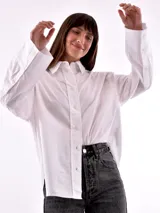 Camisa blanca a rayas verticales color ladrillo, de corte recto y mangas largas con puños abotonados.