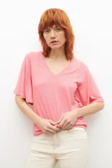 Remera fucsia de canalé con escote en V y mangas cortas con volados.