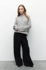 Polera tejida color borgoña, de cuello alto y mangas largas abullonadas con detalle de bordado trenzado en los puños.