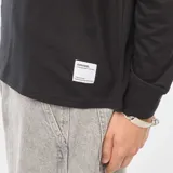 Camiseta negra de punto, de manga larga y cuello redondo.