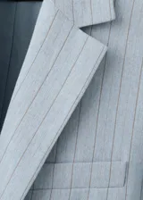 Blazer de corte sastre en color celeste con estampado de raya diplomática, cuello de solapa con muesca, cierre frontal de un botón, bolsillos con solapa en los laterales y bolsillo de ribete en el pecho.