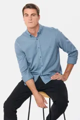 Camisa de manga larga color verde oscuro, con cuello abotonado y logo bordado en el pecho.