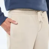 Pantalón de chándal beige liso con cordones ajustables en la cintura.