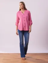 Blusa Ninety color beige con textura, cuello base con escote en V y abertura central con botones. Tiene un bolsillo en el pecho y mangas 3/4 regulables con presilla y botón.