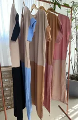 Vestido largo estilo túnica de algodón con diseño bicolor, cuerpo en tono tostado y parte inferior negra, de manga corta y cuello redondo.