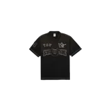 Remera polo Supreme de manga corta en color negro, con cuello clásico, cierre frontal de botones y detalles de costuras visibles en contraste. Cuenta con aplicaciones bordadas con logotipos en el frente y la manga.