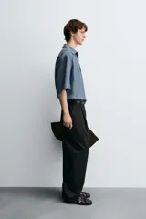 Camisa polo de calce relajado confeccionada en tejido de lino color azul. Presenta cuello solapa con abertura frontal en V y manga corta.